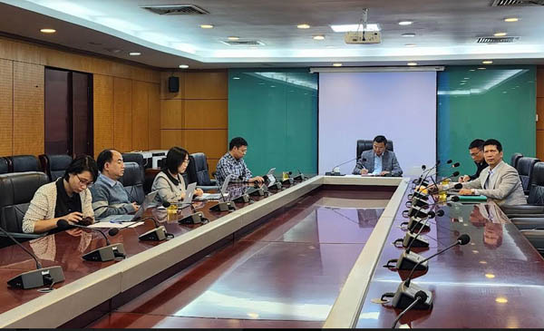 A group of people sitting at long tables in a conference roomDescription automatically generated with medium confidence