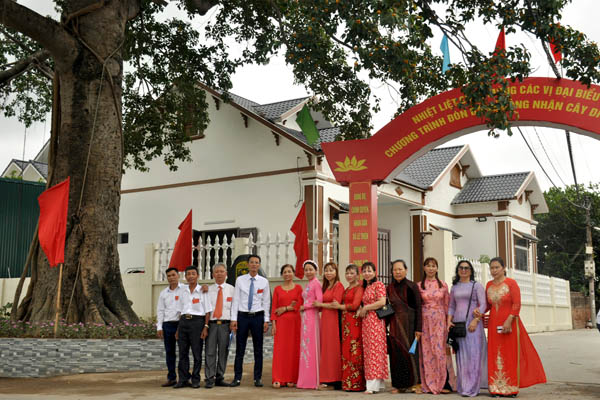 A group of people posing for a photo in front of a buildingDescription automatically generated