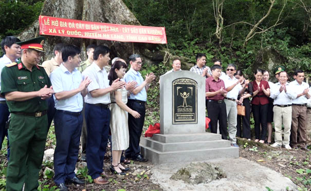 A group of people standing around a graveDescription automatically generated with medium confidence