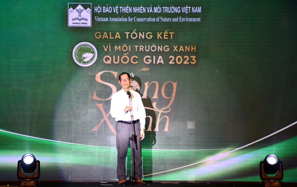 A person standing on a stage with a microphoneDescription automatically generated