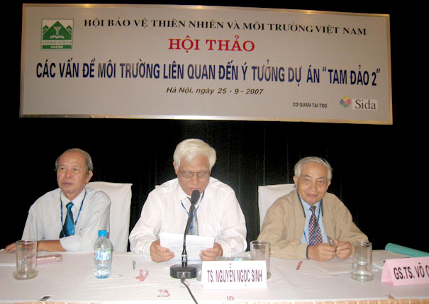 A group of men sitting at a table with microphonesDescription automatically generated with medium confidence