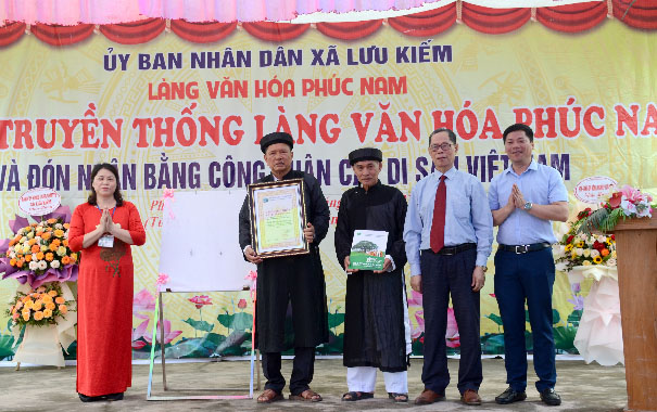 A group of people standing in front of a bannerDescription automatically generated