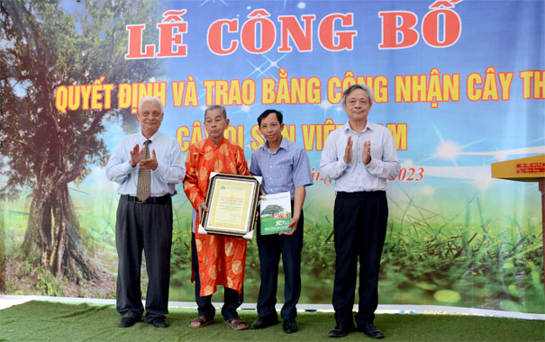 A group of men standing in front of a bannerDescription automatically generated