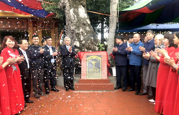 A group of men standing in front of a signDescription automatically generated