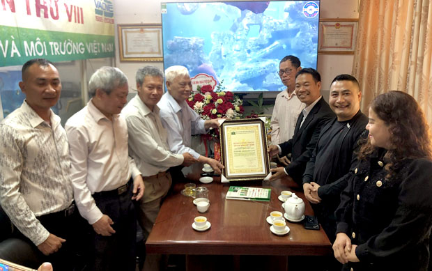 A group of men standing around a table with a certificateDescription automatically generated
