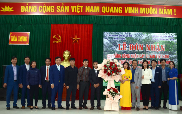A group of people standing in front of a bannerDescription automatically generated