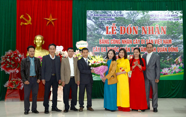 A group of people standing in front of a bannerDescription automatically generated