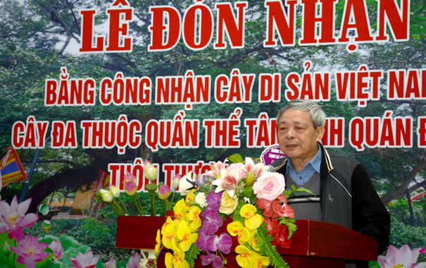 A person standing at a podium with flowersDescription automatically generated