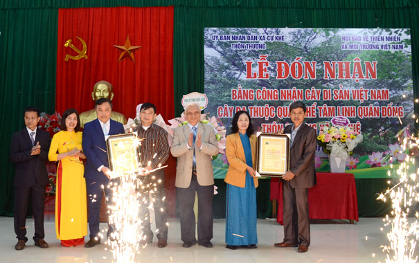 A group of people standing in front of a bannerDescription automatically generated