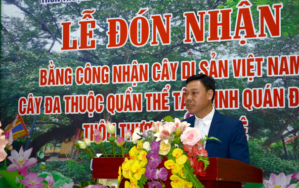 A person standing at a podium with flowersDescription automatically generated