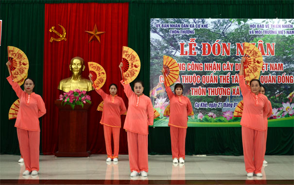 A group of women in orange outfits on a stageDescription automatically generated