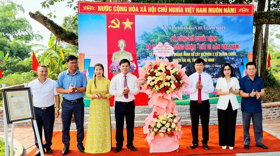 A group of people standing in front of a bannerDescription automatically generated