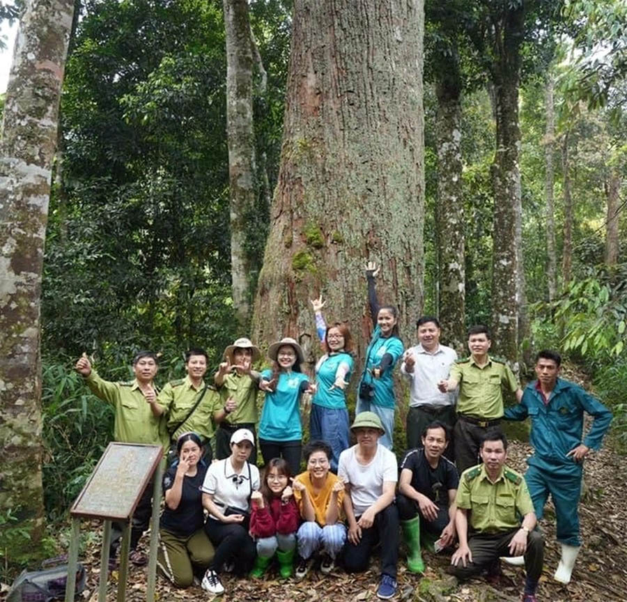 A group of people posing for a photo in the woodsDescription automatically generated