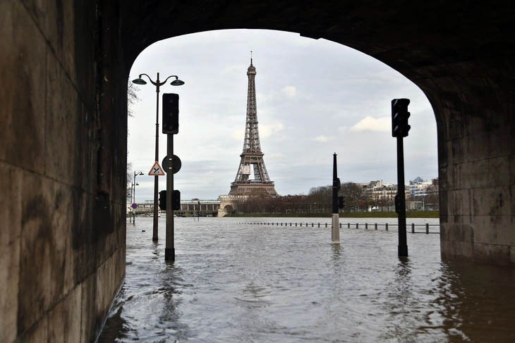 A flooded street and a towerDescription automatically generated