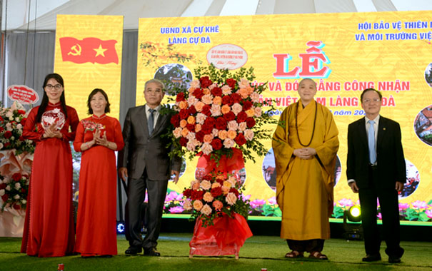 A group of people standing in front of a large flower arrangementDescription automatically generated