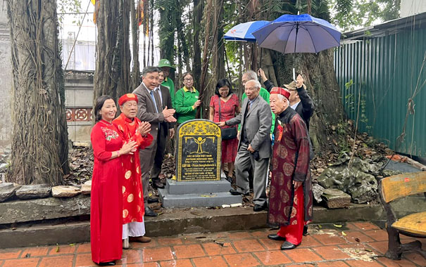 A group of people standing around a graveDescription automatically generated