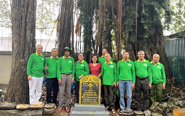 A group of people standing in front of a graveDescription automatically generated