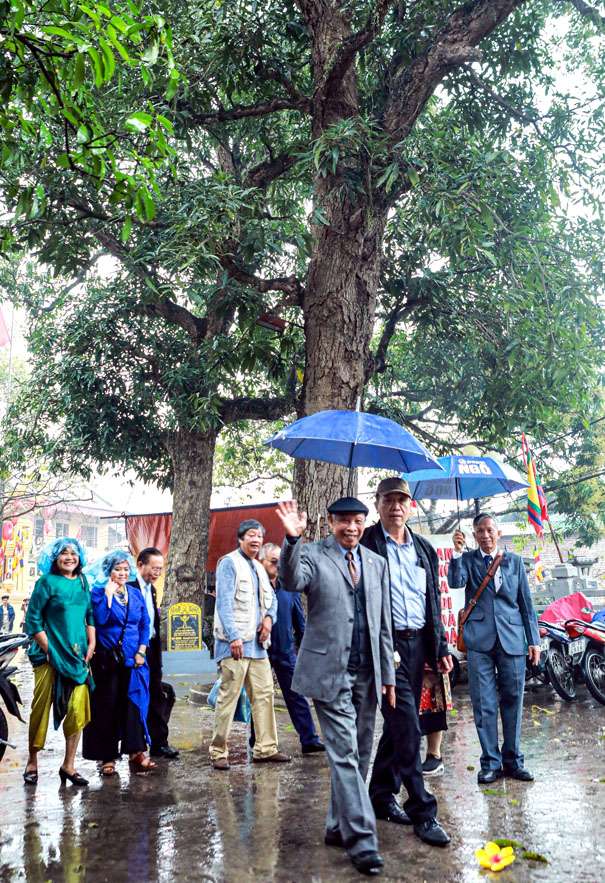 A group of people standing under umbrellasDescription automatically generated
