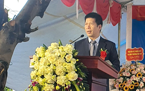 A person standing at a podium with a bouquet of flowersDescription automatically generated