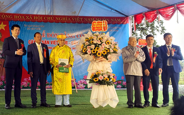 A group of people standing in front of a signDescription automatically generated