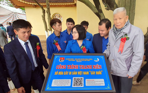 A group of people standing around a signDescription automatically generated