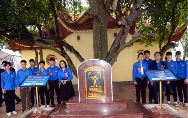 A group of people standing in front of a monumentDescription automatically generated