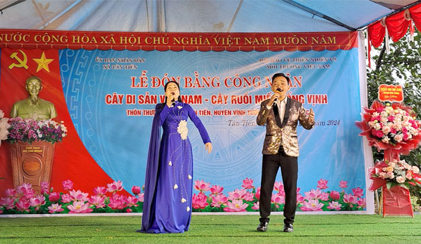 A person and person singing on a stageDescription automatically generated