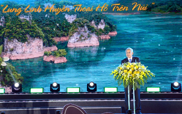 A person standing at a podium with a podium and a flower bouquetDescription automatically generated