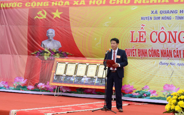 A person standing in front of a bannerDescription automatically generated