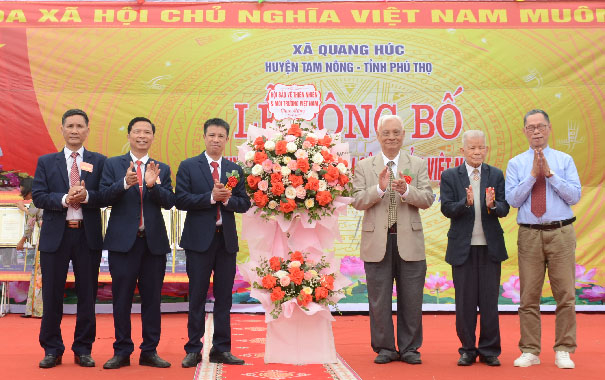 A group of men standing in front of a flower arrangementDescription automatically generated