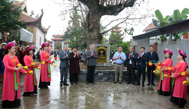 A group of people standing in front of a treeDescription automatically generated