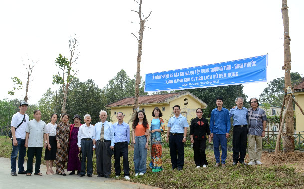 A group of people standing in front of a bannerDescription automatically generated