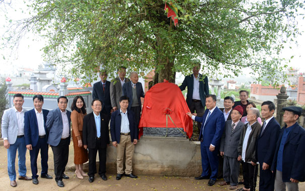 A group of people standing under a treeDescription automatically generated