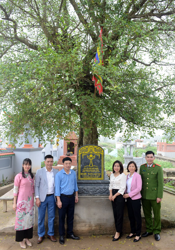 A group of people standing under a treeDescription automatically generated