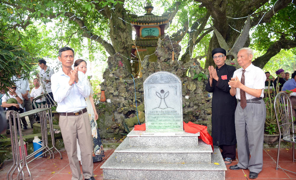 A group of people standing in front of a graveDescription automatically generated