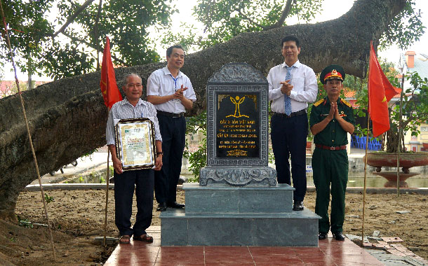 A group of men standing next to a graveDescription automatically generated