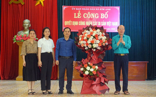 A group of people standing in front of a signDescription automatically generated