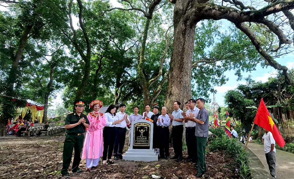 A group of people standing under a treeDescription automatically generated