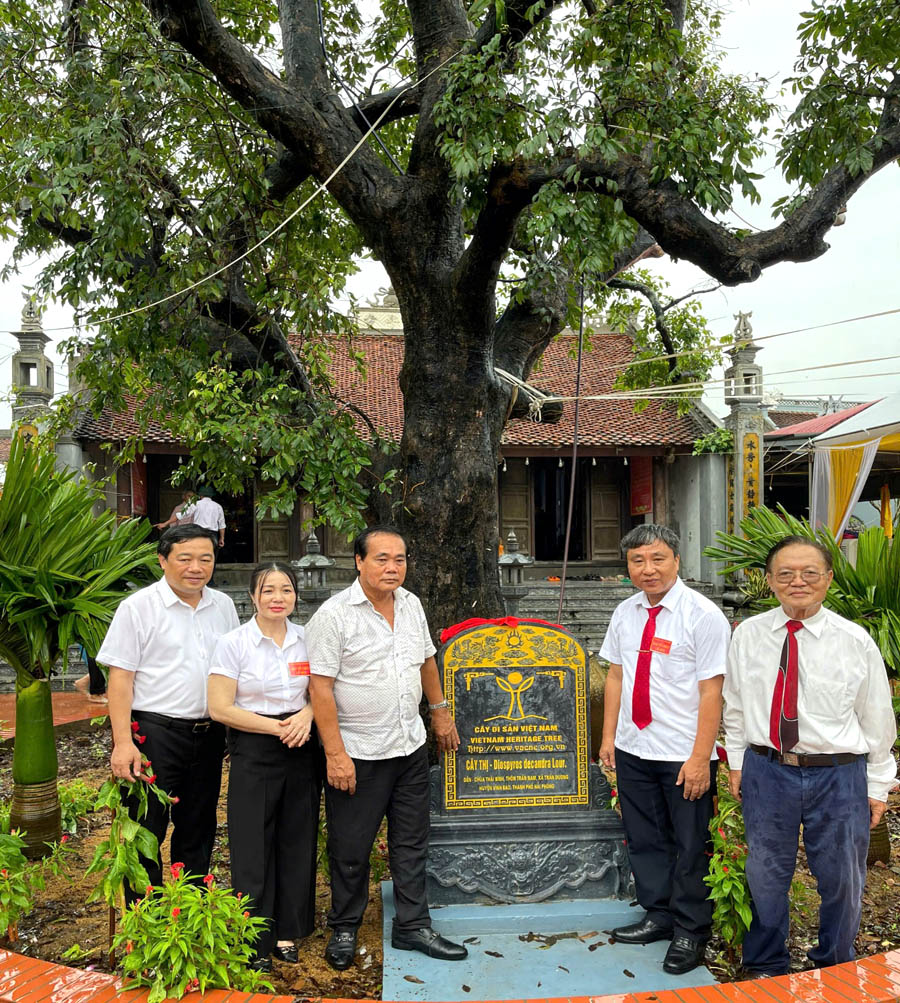 A group of people standing in front of a graveDescription automatically generated