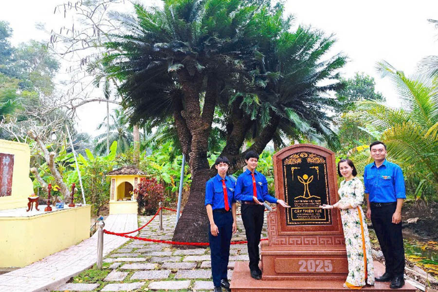 A group of people standing next to a signDescription automatically generated