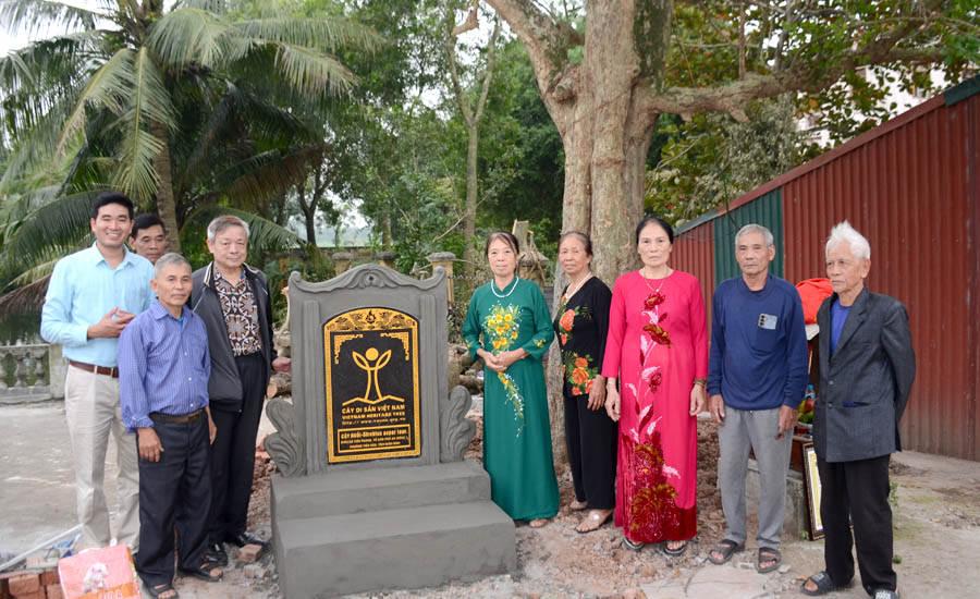 A group of people standing next to a grave stoneAI-generated content may be incorrect.