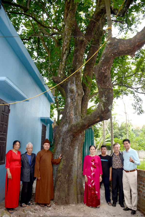 A group of people standing next to a treeAI-generated content may be incorrect.