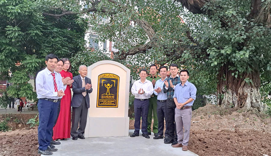 A group of people standing in front of a plaqueAI-generated content may be incorrect.