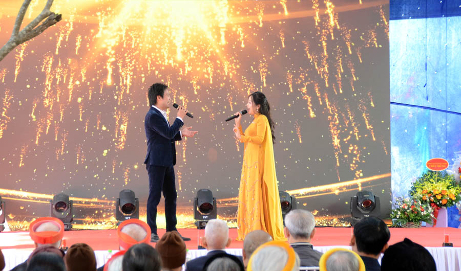 A person and person on a stage with microphonesAI-generated content may be incorrect.