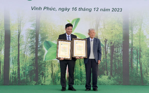 Men holding certificates in front of a bannerDescription automatically generated