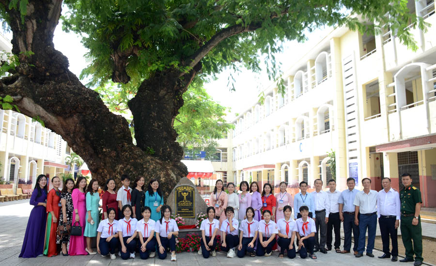 A group of people posing under a treeAI-generated content may be incorrect.