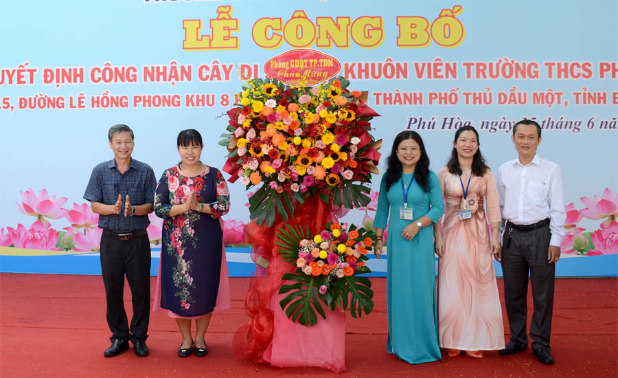 A group of people standing next to a large flower displayAI-generated content may be incorrect.